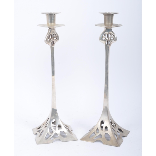 83 - A pair of c1920s Art Nouveau silver coloured white metal candle stick holders of naturalistic column... 