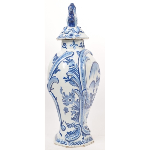 122 - An early 20th century earthenware urn / lidded vase, with moulded lion / dog mounted atop, seated up... 