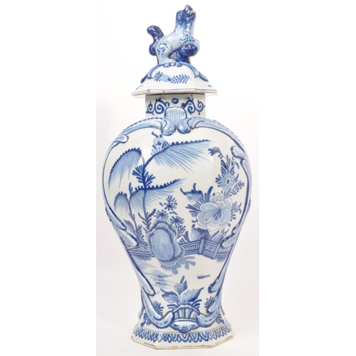 122 - An early 20th century earthenware urn / lidded vase, with moulded lion / dog mounted atop, seated up... 