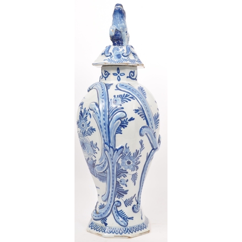 122 - An early 20th century earthenware urn / lidded vase, with moulded lion / dog mounted atop, seated up... 