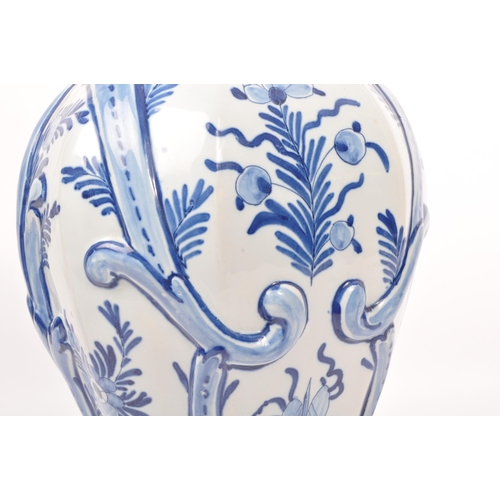 122 - An early 20th century earthenware urn / lidded vase, with moulded lion / dog mounted atop, seated up... 