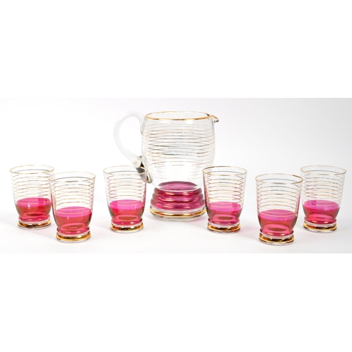 125 - A set of vintage retro cranberry drinking glasses with matching jug. Comprising of; 6 x matching
 dr... 