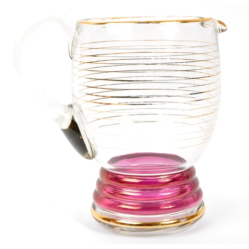 125 - A set of vintage retro cranberry drinking glasses with matching jug. Comprising of; 6 x matching
 dr... 