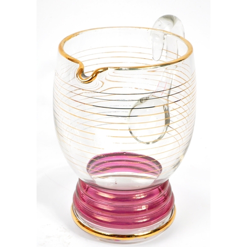 125 - A set of vintage retro cranberry drinking glasses with matching jug. Comprising of; 6 x matching
 dr... 