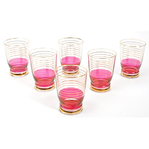 125 - A set of vintage retro cranberry drinking glasses with matching jug. Comprising of; 6 x matching
 dr... 