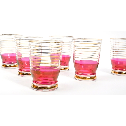 125 - A set of vintage retro cranberry drinking glasses with matching jug. Comprising of; 6 x matching
 dr... 