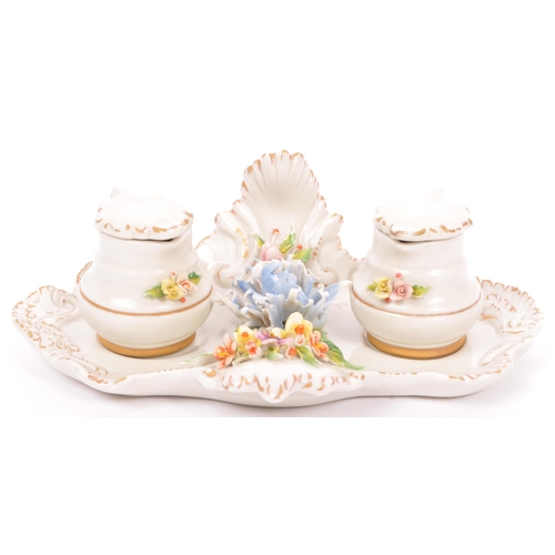133 - A vintage 20th Century Capodimonte marked porcelain inkwell and two jugs, with china flower relief t... 