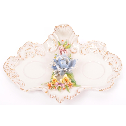 133 - A vintage 20th Century Capodimonte marked porcelain inkwell and two jugs, with china flower relief t... 