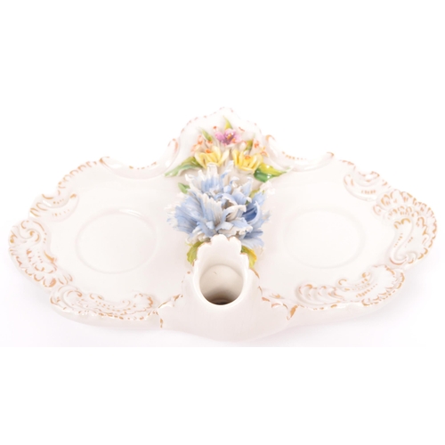 133 - A vintage 20th Century Capodimonte marked porcelain inkwell and two jugs, with china flower relief t... 