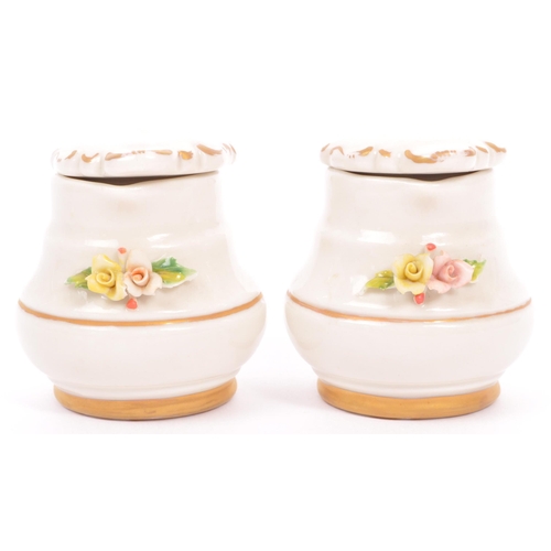 133 - A vintage 20th Century Capodimonte marked porcelain inkwell and two jugs, with china flower relief t... 