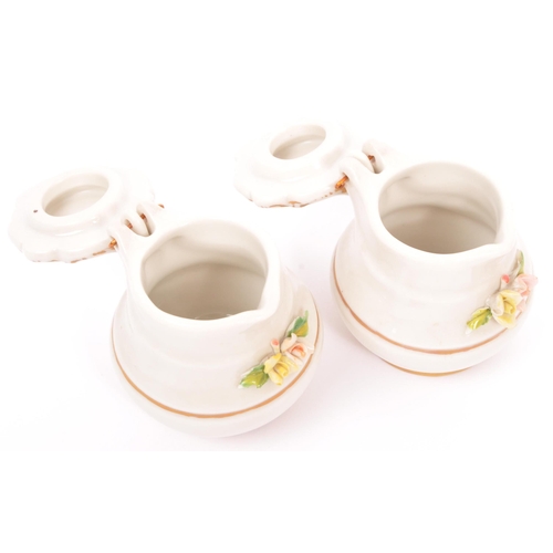 133 - A vintage 20th Century Capodimonte marked porcelain inkwell and two jugs, with china flower relief t... 