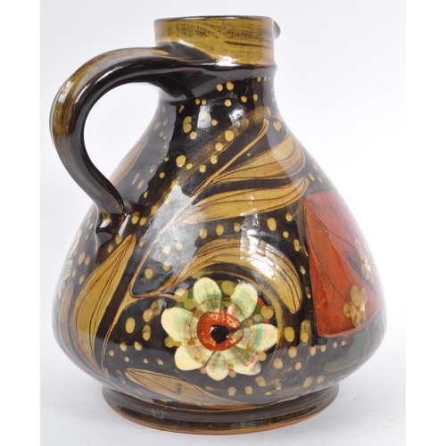 167 - A large Continental ceramic glazed Hans Schneider Folk Art pottery jug of bulbous form together with... 