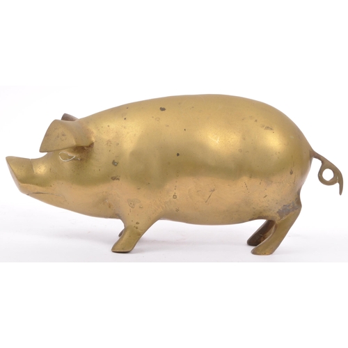 173 - An early 20th Century 1930s large brass figure in the form of a pig with stylised features, standing... 