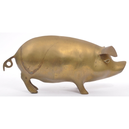 173 - An early 20th Century 1930s large brass figure in the form of a pig with stylised features, standing... 