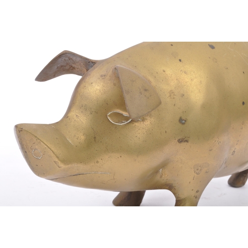 173 - An early 20th Century 1930s large brass figure in the form of a pig with stylised features, standing... 