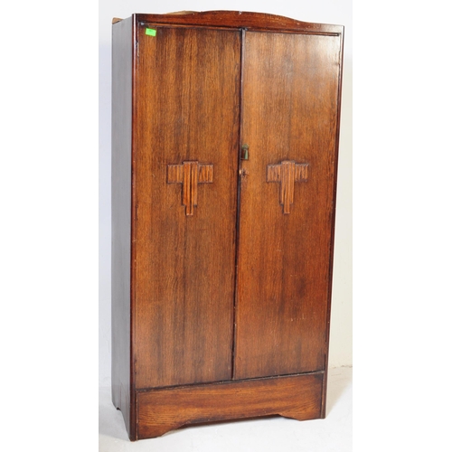 561 - A 1930s Art Deco oak bachelors wardrobe. Raised on an plinth leg base with twin full length oak vene... 