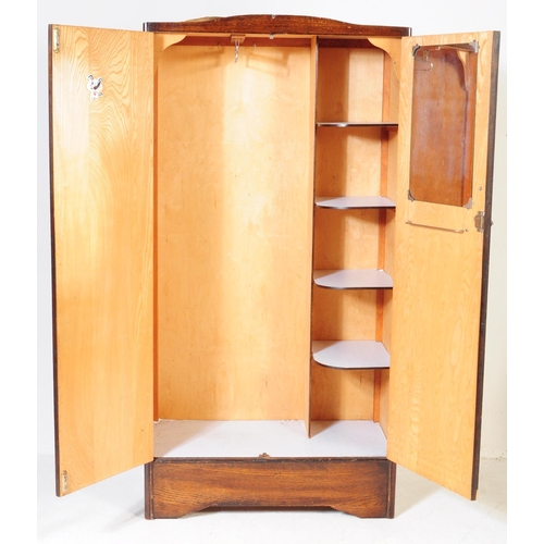 561 - A 1930s Art Deco oak bachelors wardrobe. Raised on an plinth leg base with twin full length oak vene... 