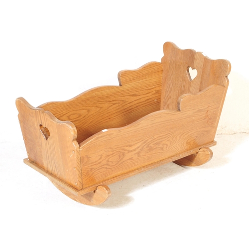 575 - A vintage late 19th century Victorian child's oak rocking cradle. The cradle with solid panels on ca... 