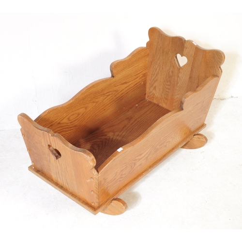 575 - A vintage late 19th century Victorian child's oak rocking cradle. The cradle with solid panels on ca... 