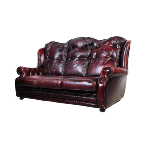 1001 - A vintage 20th century button back chesterfield three seater sofa settee couch. In oxblood colour wi... 
