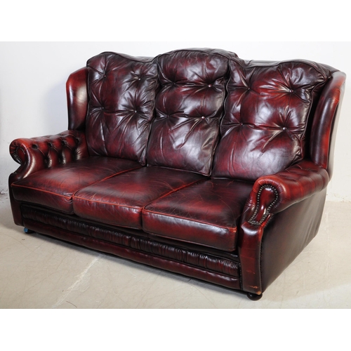 1001 - A vintage 20th century button back chesterfield three seater sofa settee couch. In oxblood colour wi... 