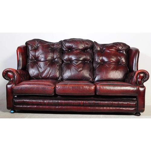 1001 - A vintage 20th century button back chesterfield three seater sofa settee couch. In oxblood colour wi... 