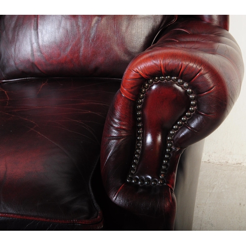 1001 - A vintage 20th century button back chesterfield three seater sofa settee couch. In oxblood colour wi... 