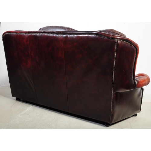 1001 - A vintage 20th century button back chesterfield three seater sofa settee couch. In oxblood colour wi... 