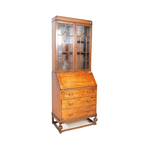 1003 - A 1920s George V oak bureau bookcase. The bureau being raised on shaped supports having a fall front... 