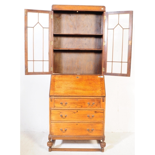 1003 - A 1920s George V oak bureau bookcase. The bureau being raised on shaped supports having a fall front... 