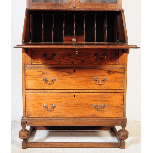 1003 - A 1920s George V oak bureau bookcase. The bureau being raised on shaped supports having a fall front... 