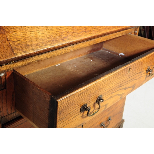 1003 - A 1920s George V oak bureau bookcase. The bureau being raised on shaped supports having a fall front... 