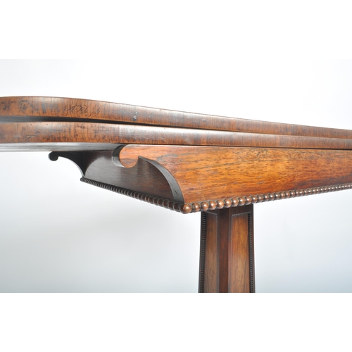 108 - A 19th century William IV rosewood games / card fold over table. The table having a rounded rectangu... 