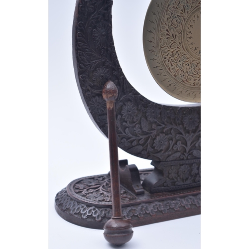 109 - An early 20th century Indian Kashmiri carved oak wood & brass crescent dinner table gong. The gong h... 