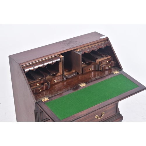 138 - A miniature George III style mahogany bureau. The Bureau desk having a fall front top section with f... 