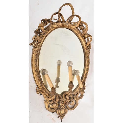 14 - An 18th century George III oval gilt girandole mirror of Rococo taste. The frame of giltwood and ges... 