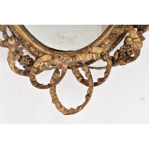 14 - An 18th century George III oval gilt girandole mirror of Rococo taste. The frame of giltwood and ges... 