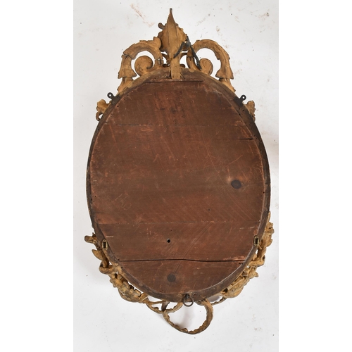 14 - An 18th century George III oval gilt girandole mirror of Rococo taste. The frame of giltwood and ges... 