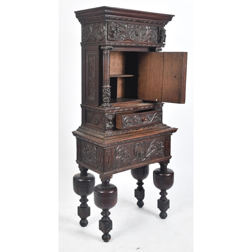 180 - A 17th century heavily carved oak Flemish cabinet on stand. The cabinet top having a flyaway cornice... 