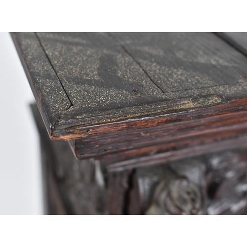 180 - A 17th century heavily carved oak Flemish cabinet on stand. The cabinet top having a flyaway cornice... 