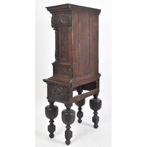 180 - A 17th century heavily carved oak Flemish cabinet on stand. The cabinet top having a flyaway cornice... 