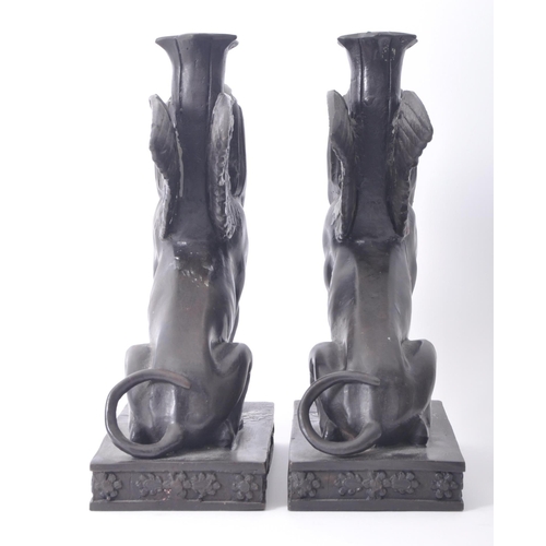 196 - A pair of 20th century bronze patinated Egyptian revival Sphinx candlestick holders. The sphinxes ea... 