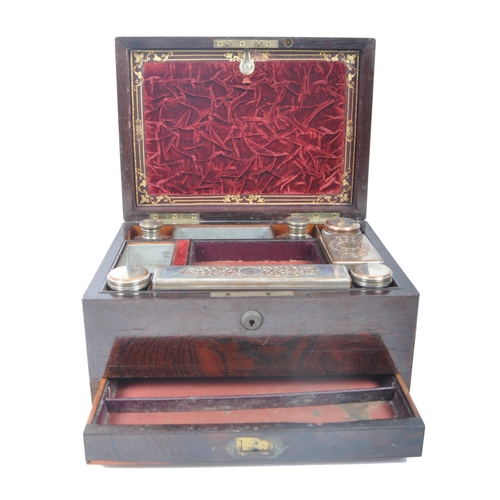 211 - A 19th century rosewood ladies travelling vanity case. The rosewood box with central oval brass mono... 