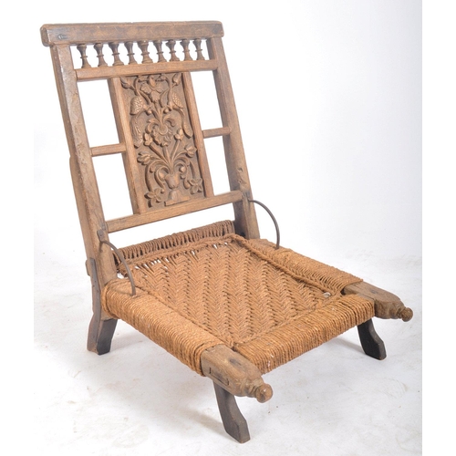 216 - A set of four early 20th century carved wood Indian Pida Rajasthani low chairs. Each having a carved... 