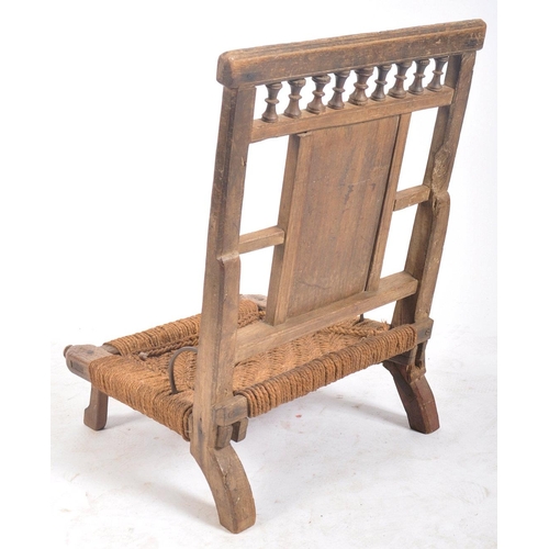 216 - A set of four early 20th century carved wood Indian Pida Rajasthani low chairs. Each having a carved... 