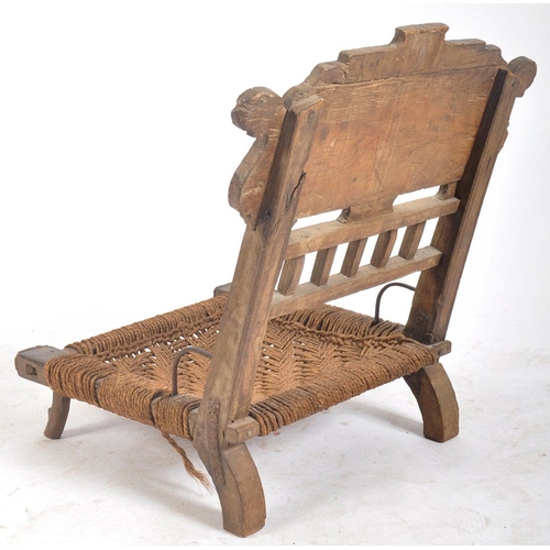 216 - A set of four early 20th century carved wood Indian Pida Rajasthani low chairs. Each having a carved... 