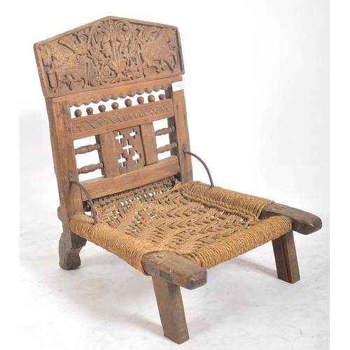 216 - A set of four early 20th century carved wood Indian Pida Rajasthani low chairs. Each having a carved... 