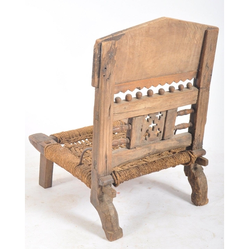 216 - A set of four early 20th century carved wood Indian Pida Rajasthani low chairs. Each having a carved... 