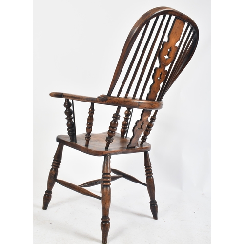 224 - A mid 19th century Victorian oak and yew Windsor armchair. The chair with arched wheel back, christm... 