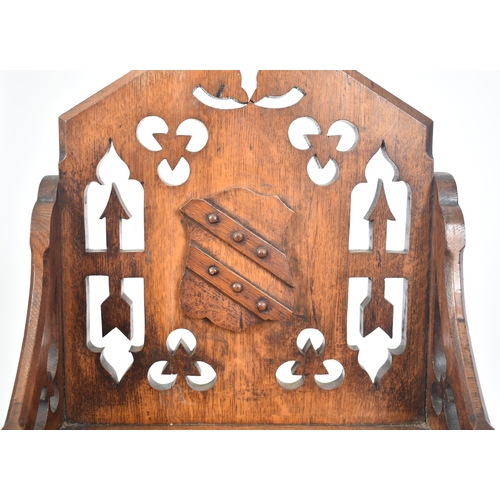 228 - A Victorian 19th century oak Gothic style ecclesiastical church low chair. The chair having a pierce... 